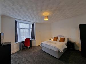 a bedroom with a bed and a desk and a window at Nice Living Serviced Accommodations Leicester in Leicester