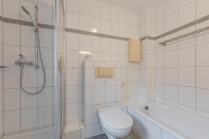 ein weißes Badezimmer mit Toilette und Dusche in der Unterkunft Fischerhaus 316 in Rechlin