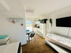 a bedroom with a bed and a desk with a tv at INDIGO Luna in Ursensollen