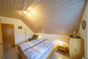 ein Schlafzimmer mit einem großen Bett und einer Holzdecke in der Unterkunft Am Priel 20 DG in Otterndorf