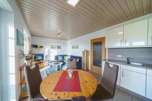 a kitchen and dining room with a wooden table at Am Priel 20 EG in Otterndorf +13 photos