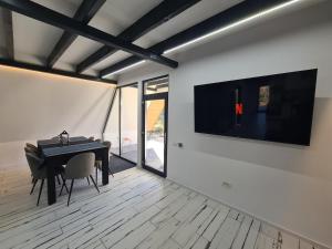 a room with a piano and a television on a wall at The House in Corbi