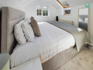 a bedroom with a large bed with pillows at Sea Salt - Beer, East Devon in Beer