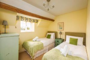 ein Schlafzimmer mit zwei Betten und einem Fenster in der Unterkunft 18th Century Cottage in Dorset Countryside in Horton