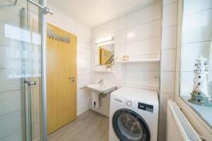 a laundry room with a washing machine and a sink at Am Priel 20 EG in Otterndorf