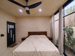 a bedroom with a bed with a ceiling fan at Osmanthus private room in Punta Allen
