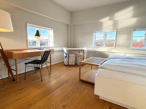een slaapkamer met een bed, een bureau en een tafel bij Pier 18 im Pierspeicher in Kappeln