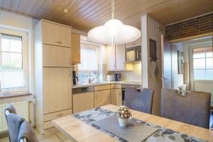 a kitchen with a wooden table and a dining room at Achtern Diek 28A in Otterndorf