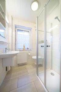 a bathroom with a shower and a sink and a toilet at Achtern Diek 28A in Otterndorf +26 photos