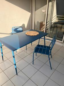 un tavolo blu e una sedia su un pavimento piastrellato di Studio Saint Gilles les Bains a Saint-Gilles-les Bains Altre 6 foto