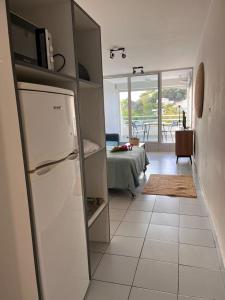 una cucina con frigorifero e una camera con tavolo di Studio Saint Gilles les Bains a Saint-Gilles-les Bains