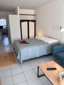 una camera da letto con un letto e un divano blu di Studio Saint Gilles les Bains a Saint-Gilles-les Bains