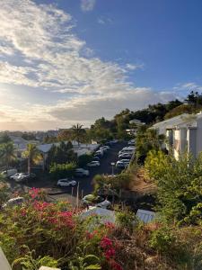 una strada cittadina con auto parcheggiate in un parcheggio di Studio Saint Gilles les Bains a Saint-Gilles-les Bains