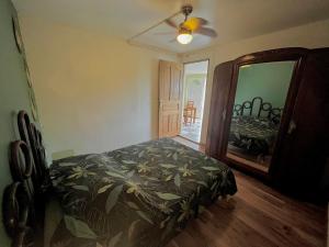 a bedroom with a bed and a dresser and a mirror at Parenthèse nature in Petite Île