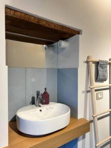 a bathroom with a white sink and a shelf at Casa I Merletti in Lunano