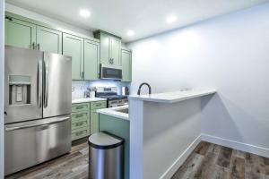 a kitchen with green cabinets and a stainless steel refrigerator at Luxury view, convenient place 304 in Juneau +2 photos