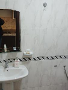 ein weißes Badezimmer mit Waschbecken und Spiegel in der Unterkunft appart hotel cabo dream in Laʼzîb