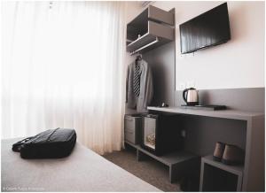 a room with a bed and a desk and a window at Hotel Caraibi - Breakfast Until 11-00 and Dinner-Mirabilandia Partner in Milano Marittima