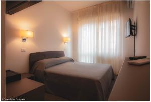 a hotel room with a bed and a window at Hotel Caraibi - Breakfast Until 11-00 and Dinner-Mirabilandia Partner in Milano Marittima +37 photos
