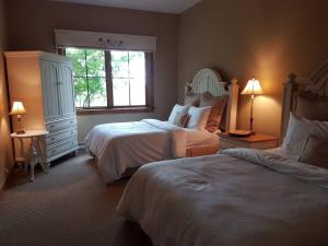 Un dormitorio con dos camas y una ventana. en Luxury Mountain Escape- Equinoxe 140-1, en Mont-Tremblant