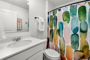 a bathroom with a toilet and a shower curtain at House Divided in Ankeny +46 photos