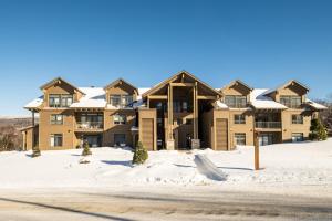 a large apartment building with snow on the ground at Verbier 6-203 Family Luxury Retreat in Mont-Tremblant