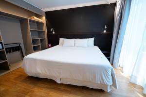 a bedroom with a white bed and a black wall at Amérian Córdoba Park Hotel in Córdoba
