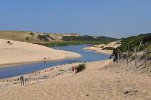 ein Strand mit Menschen, die neben einem Fluss im Sand stehen in der Unterkunft Jocelyne in Azur + 3 Fotos
