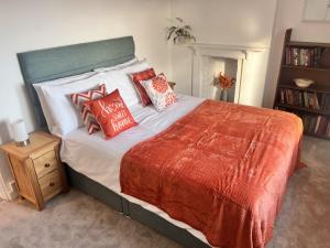 une chambre avec un grand lit avec des oreillers rouges et blancs dans l'établissement Seaview Terrace - Beer, à Beer