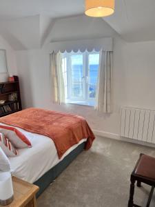 une chambre avec un lit et une grande fenêtre dans l'établissement Seaview Terrace - Beer, à Beer