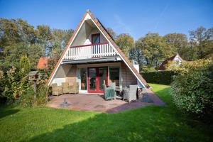 a house with a gambrel roof with a patio at Gaai I Prachtige Vakantiewoning nabij Bos in Zwiggelte +44 photos