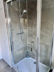 une cabine de douche avec une porte en verre et une douche. dans l'établissement Seaview Terrace - Beer, à Beer 4 autres photos