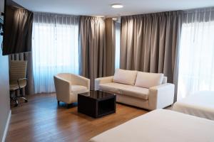 a hotel room with a bed and a couch and a chair at Amérian Córdoba Park Hotel in Córdoba