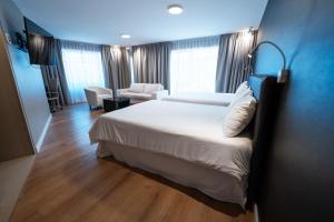 a hotel room with a large bed and a chair at Amérian Córdoba Park Hotel in Córdoba