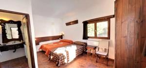 Un dormitorio con una cama, un escritorio y un espejo. en Spacious Apartment in Yeste with Shared Pool, en Yeste