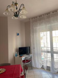 a living room with a desk and a television and a window at Appartamento ' Il sole di Vale' in Loano