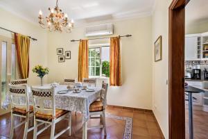 Un comedor con una mesa y sillas y una lámpara de araña. en Villa Hideaway by Algarve Villa Holidays, en Galé