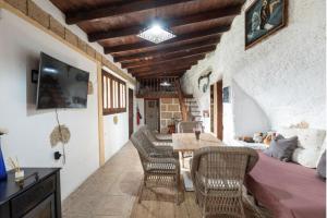 a living room with a table and chairs in a room at Arico Cave Experience in Arico