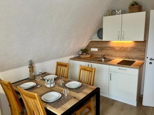 a kitchen with a table with chairs and a sink at Ferienwohnung Joanna in Norddeich