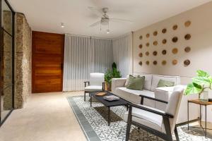 a living room with a white couch and a table at Casa Laurel 1 in Mérida
