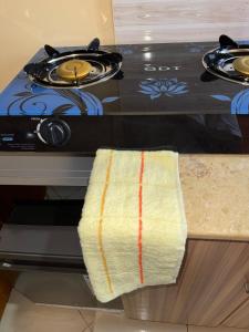 a kitchen counter with a stove with a towel on it at Haven Hub in Kampala +2 photos