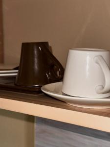 a white coffee cup on a plate on a table at Haven Hub in Kampala