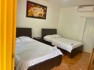 a room with two beds and a painting on the wall at Restaurante - Hotel Los Manguitos in Rivera