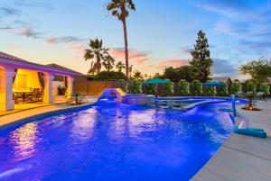 a large swimming pool with blue lighting in a backyard at LAZY RIVER POOL , Water slide, Kids outdoor play area, Arcade games in Coachella