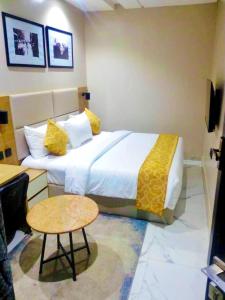 a hotel room with a large bed and a table at Ringruby Hotel, Oduduwa Way in Ikeja