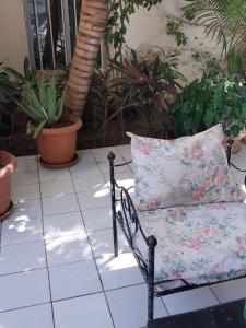 a chair with a pillow on a patio with plants at Chambre ventilée in Ngalel