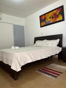 a bedroom with a bed with a painting on the wall at Restaurante - Hotel Los Manguitos in Rivera