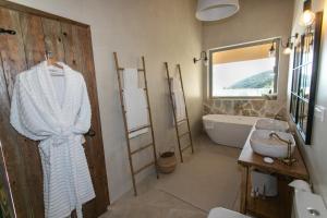 a bathroom with a bath tub and a sink and a mirror at Villa Elysium Parga in Parga +29 photos