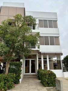 a white building with a tree in front of it at Las Casitas en Santa Elena in Santa Elena