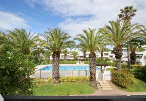 a group of palm trees in front of a swimming pool at Sol-y-Days Cyprianes appartement moderne avec piscine in La Grande-Motte